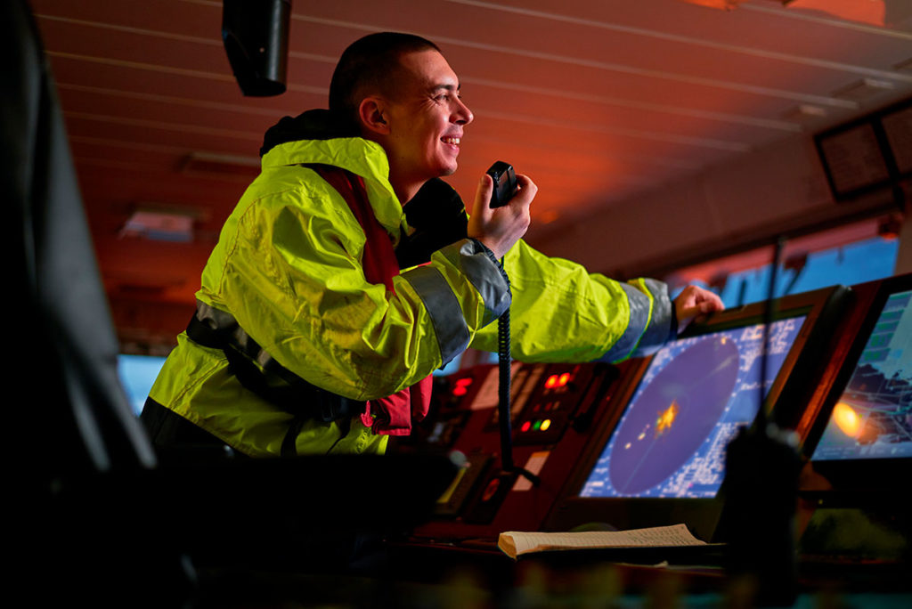 Navigator as part of ship crew performing daily duties with VHF radio.